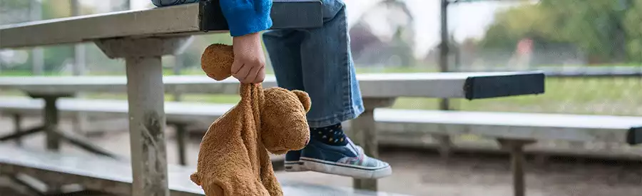 child holding stuffed bear