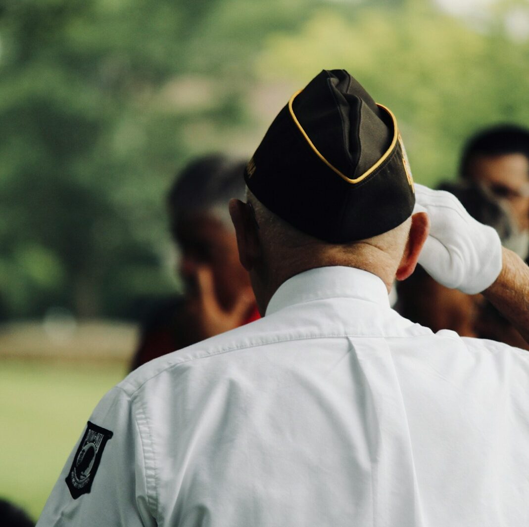 man wearing white uniform saluting