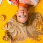 photo of woman leaning on yellow surface